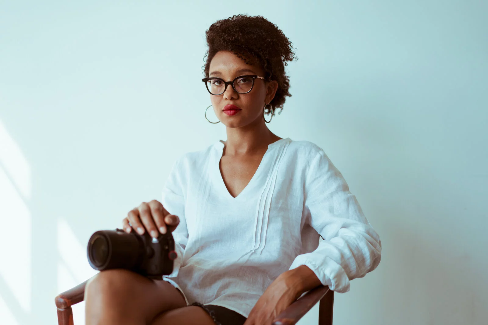 Jaimie Milner sitting down and holding a camera.