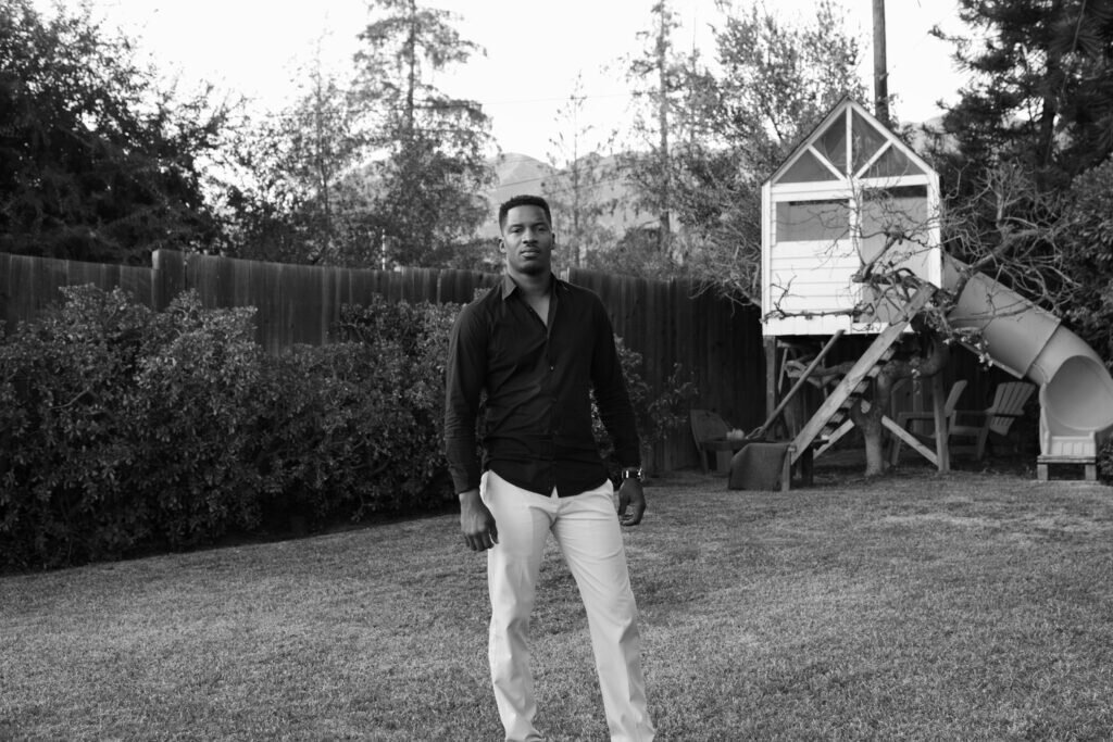 Nate Parker standing in a backyard.
