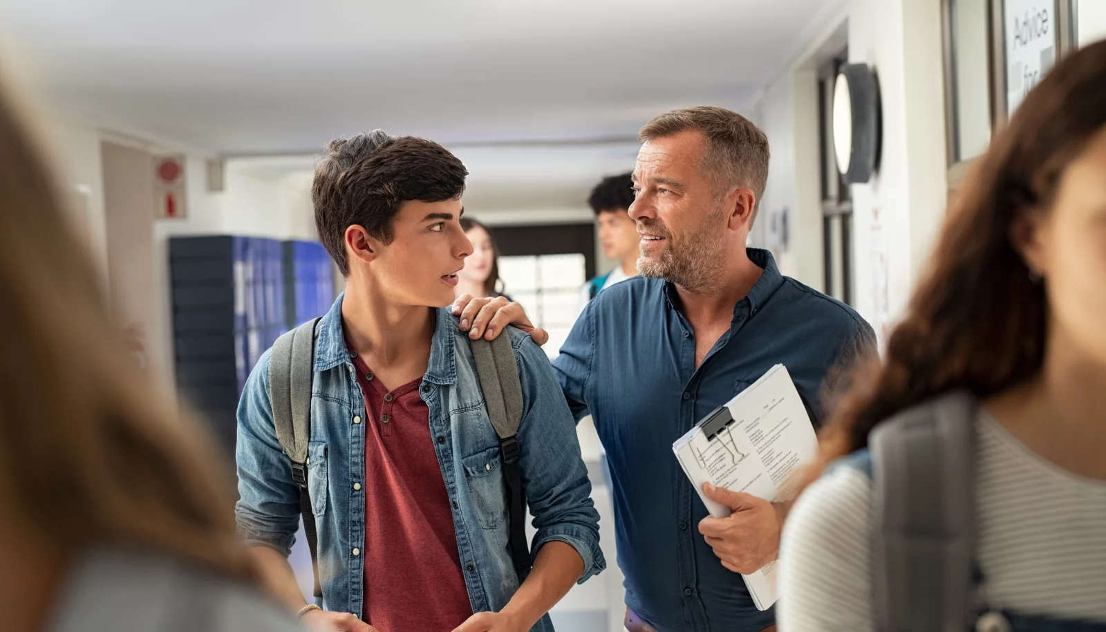 A high school boy getting career advice from a teacher.
