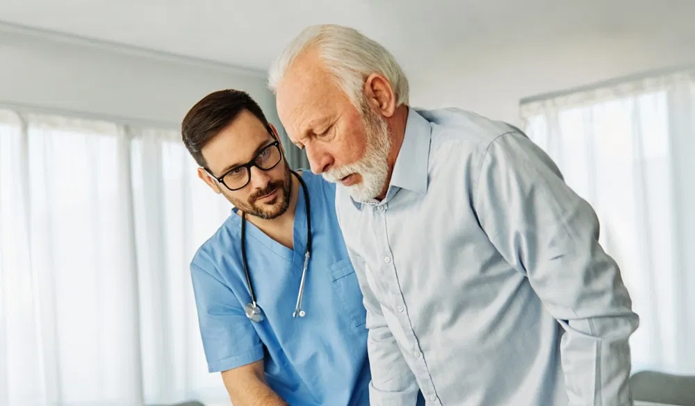 A male nurse helping an older patient