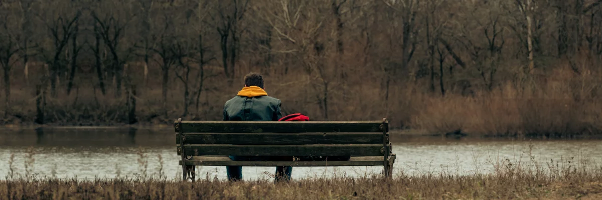 A man sitting alone at a bench. A man sitting alone at a bench.
