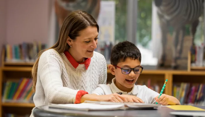 A woman tutoring a young boy.