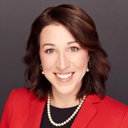 A professional headshot of Brianne Doura-Schawohl in business attire.