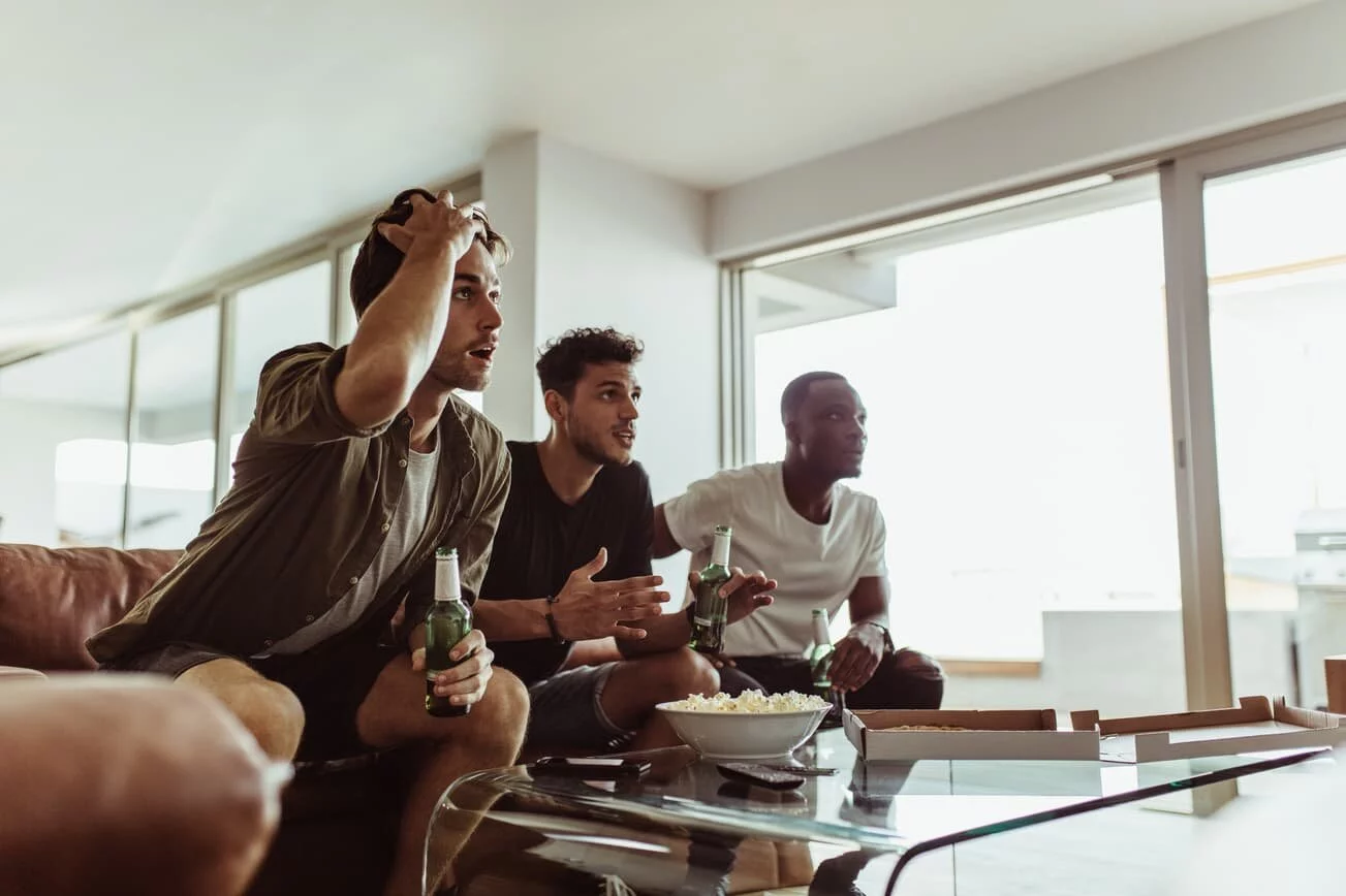 A group of guys watching sports on the couch A group of guys watching sports on the couch