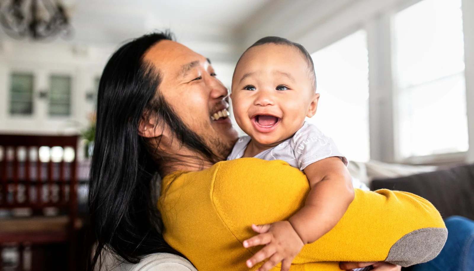 Father holds baby as they both smile