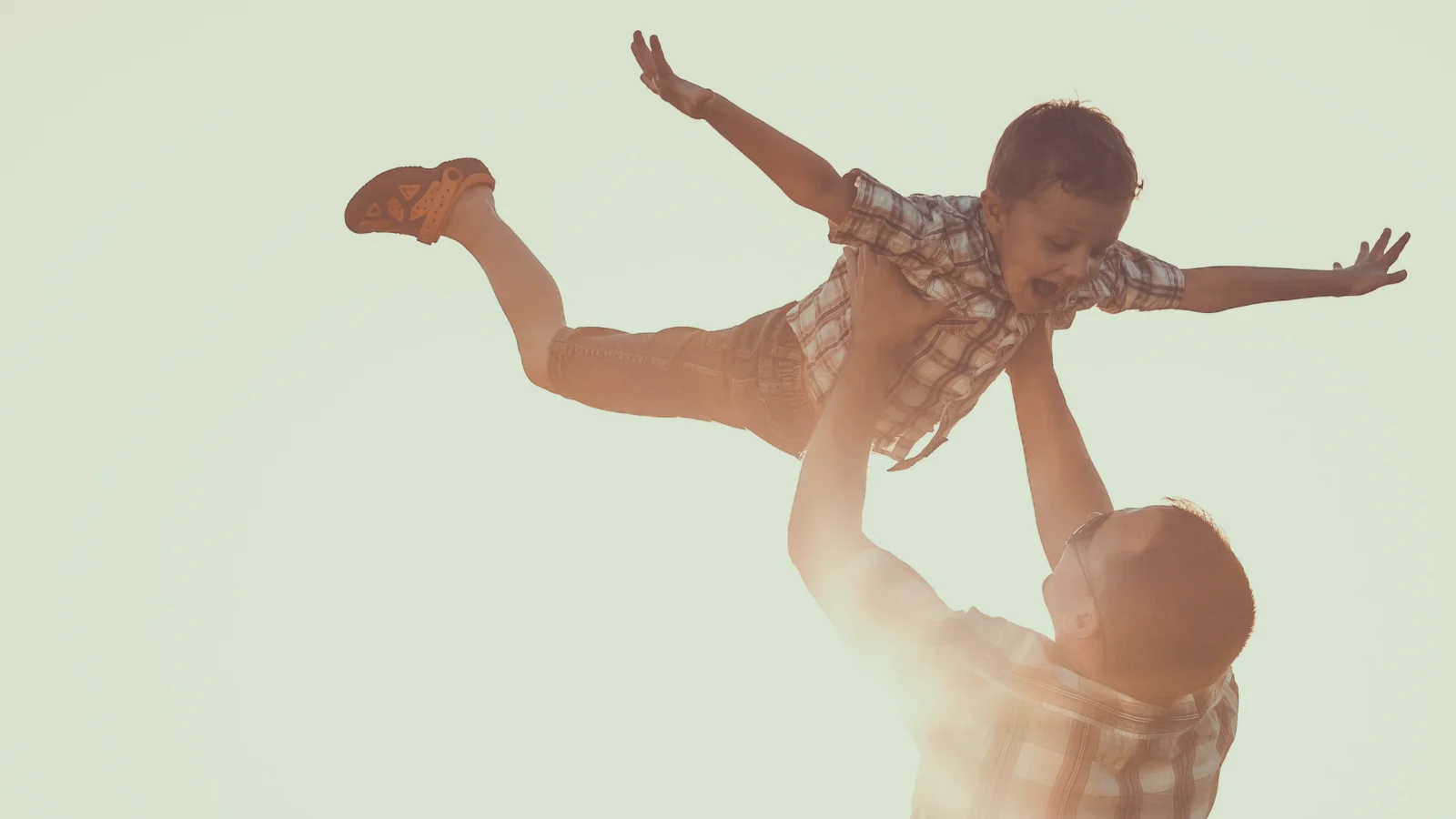 Father holds child up in the air