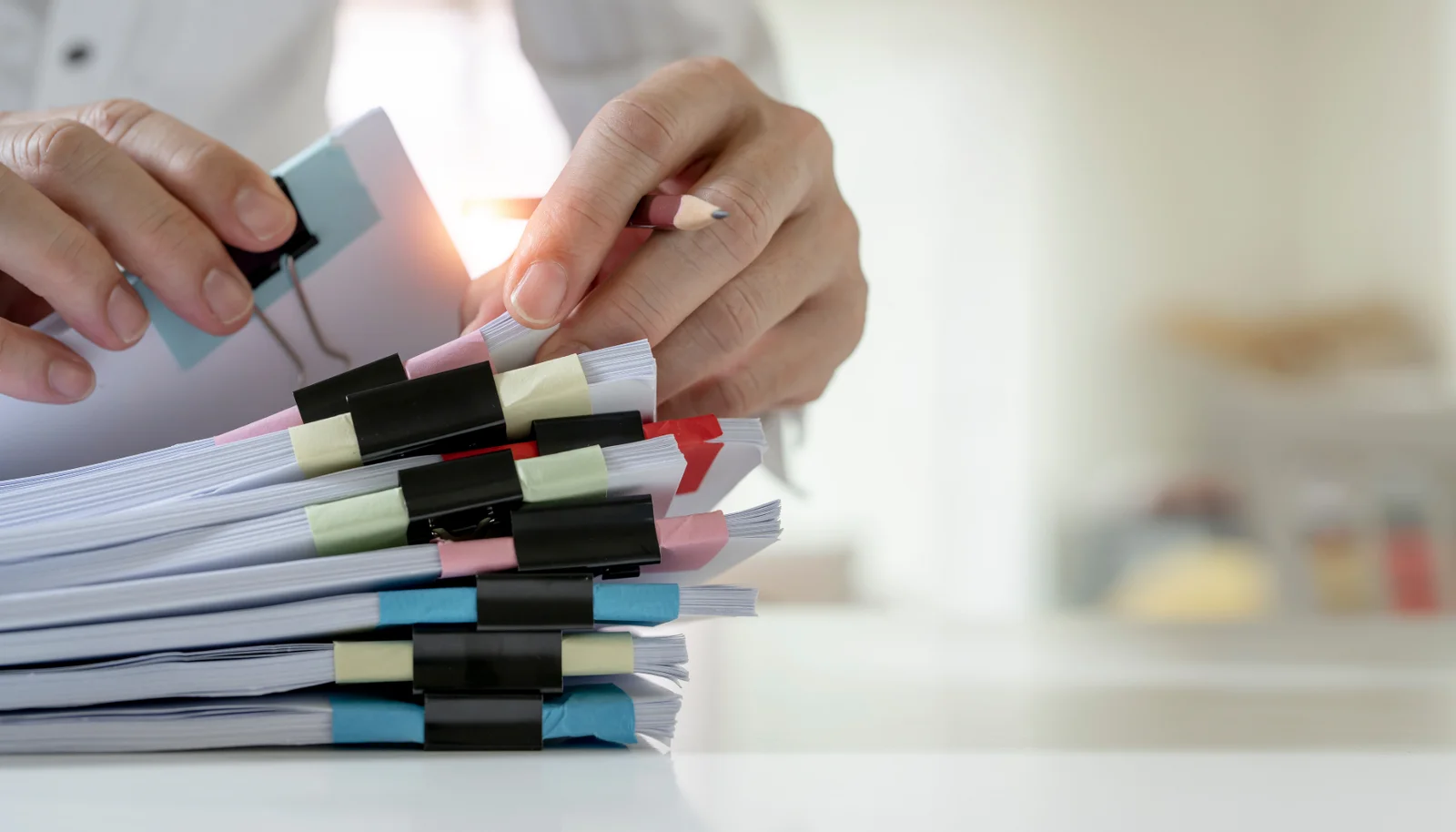 Person looking through stacks of paperwork