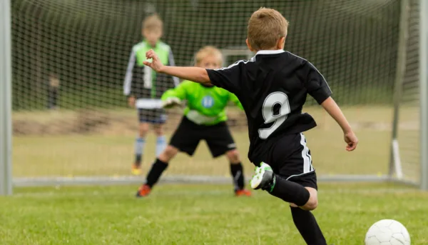 Boy about to kick ball during a soccer match