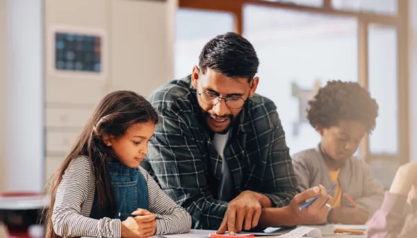 Teacher explaining assignment to student in well-lit classroom Teacher explaining assignment to student in well-lit classroom